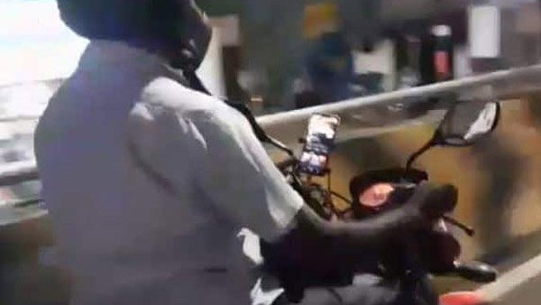 டூவீலரை ஓட்டிக்கொண்டே இந்த நபர் செய்த காரியத்தை பாருங்க... சமூக வலை தளங்களில் வைரலாகும் வீடியோ!